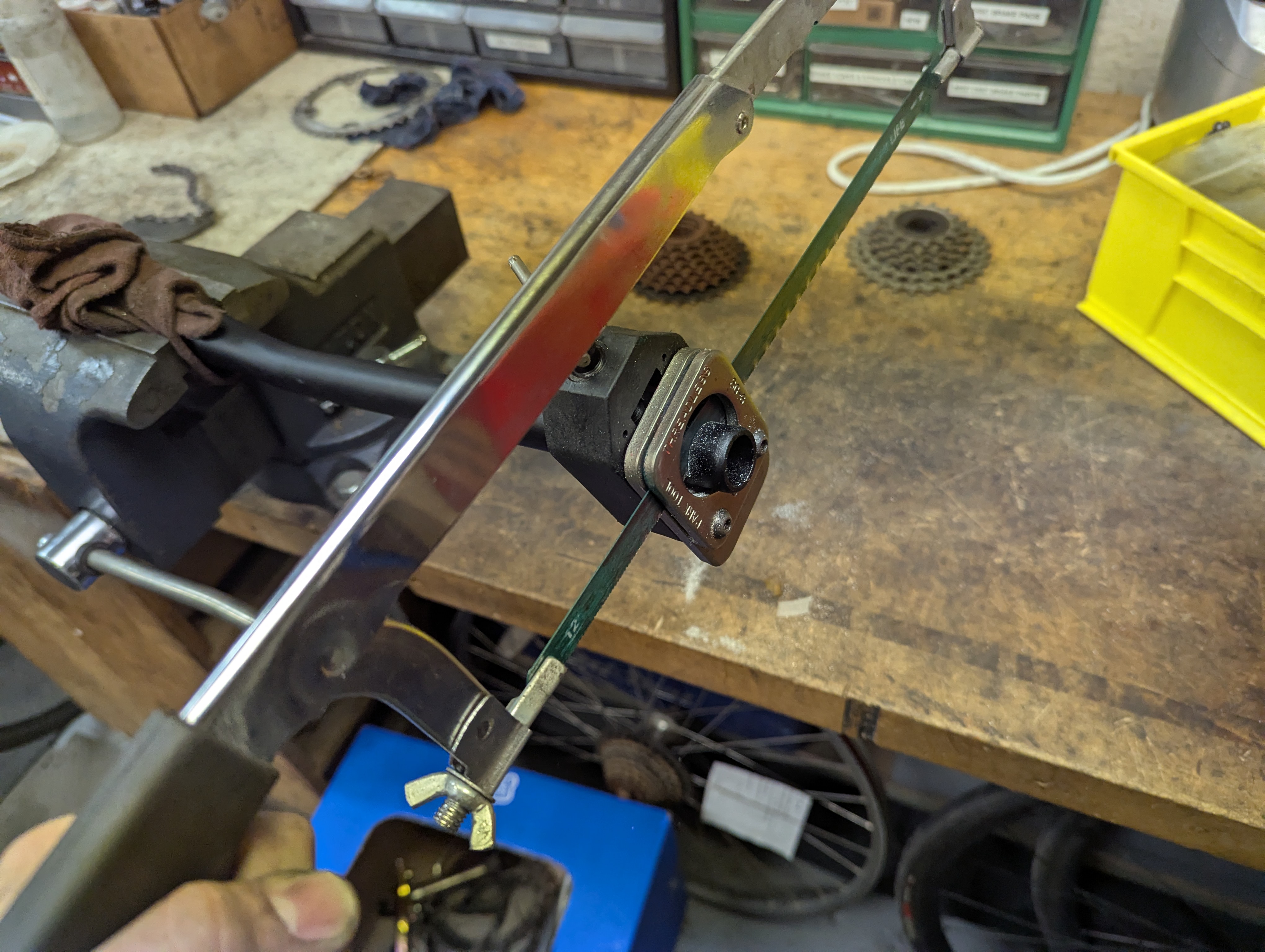 Bicycle handlebars in a vice with a guide for a hacksaw