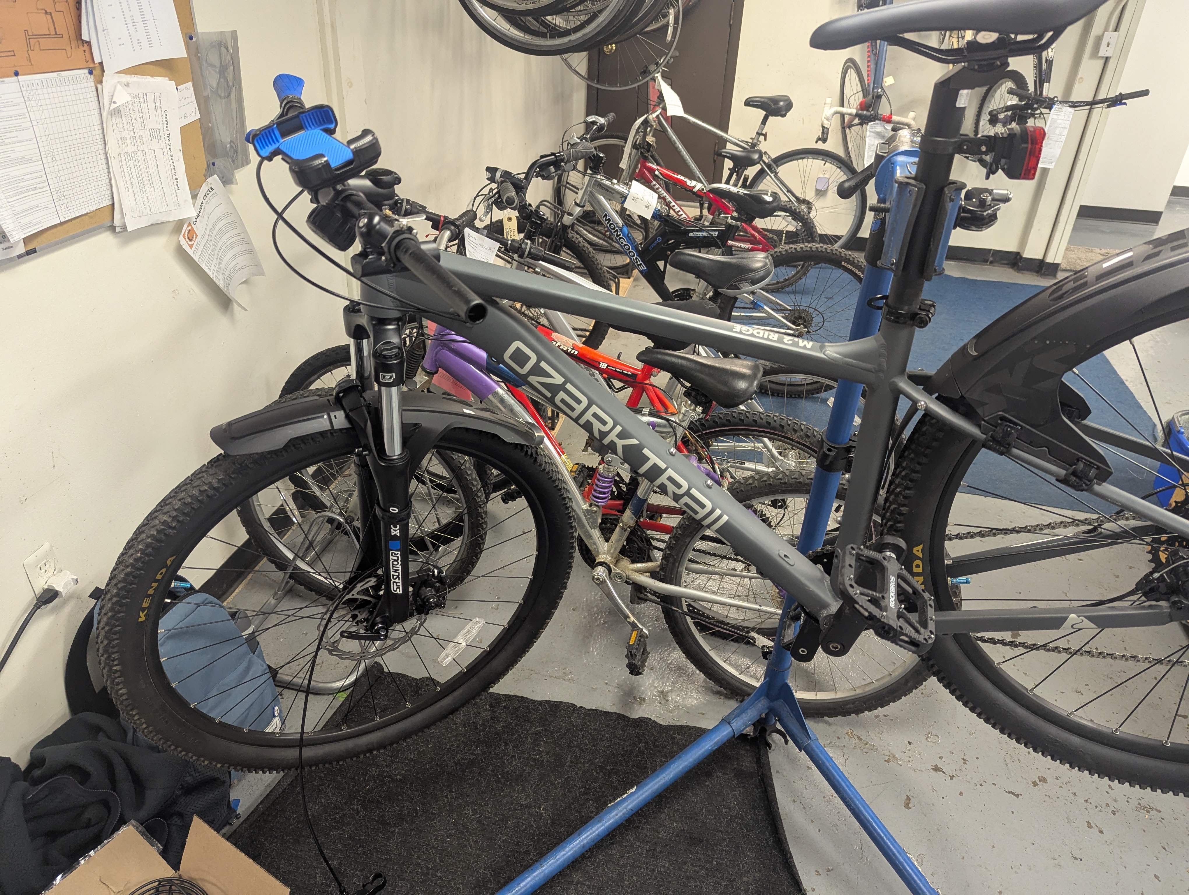 Bicycle floating on bike stand, parts are hanging from it as work is being done