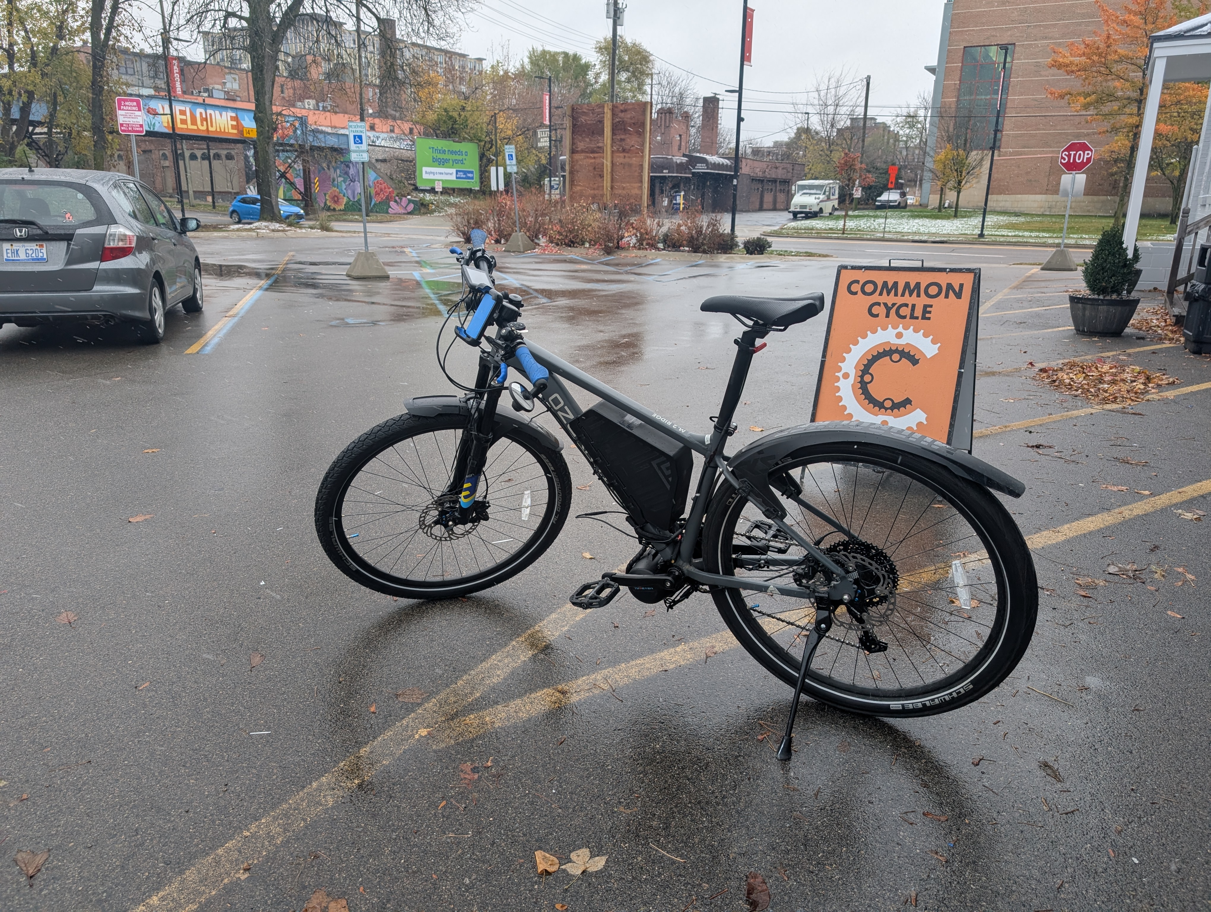 Bicycle in a parking lot, a sign saying Common Cycle is visible to the right